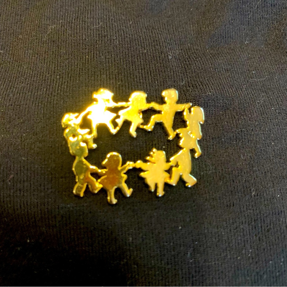 Gold-toned circle pin. Dancing children!